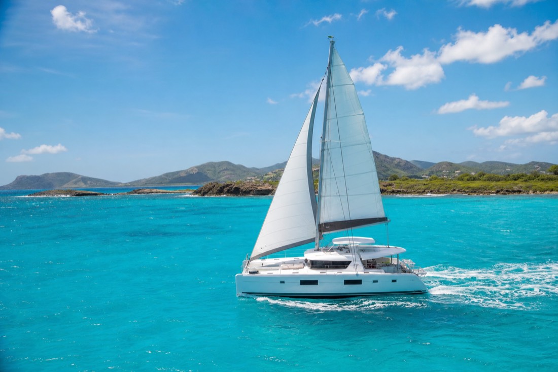 A catamaran cutting across Antigua's turquoise water